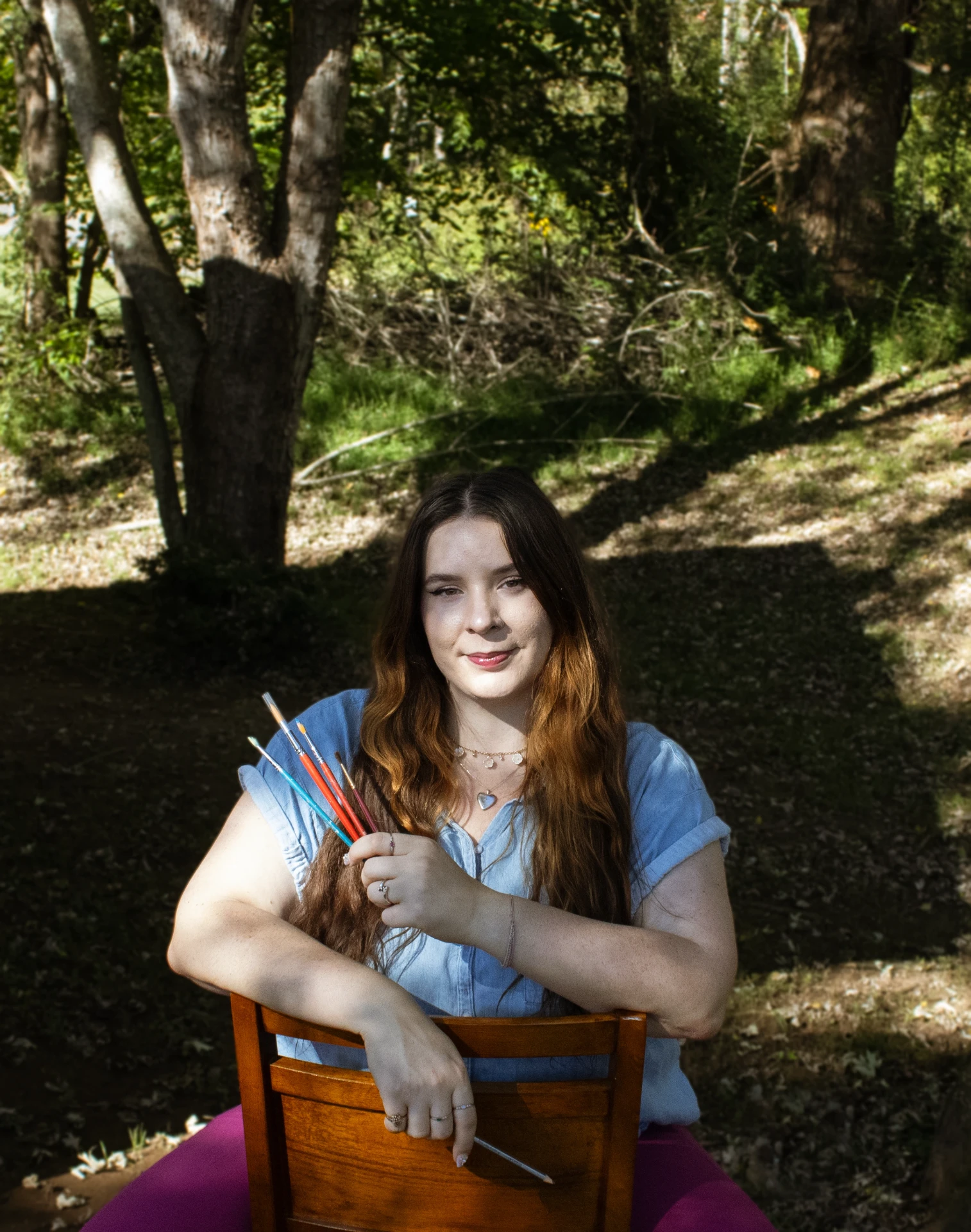 Rachel Spangler, lead illustrator for Legacy Builders, holding paint brushes